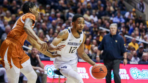 West Virginia Mountaineers guard Taz Sherman (12) dribbles past Texas Longhorns guard Donovan Williams (4) during the second half at WVU Coliseum.